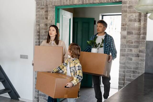 Familia llevando cajas de mudanza
